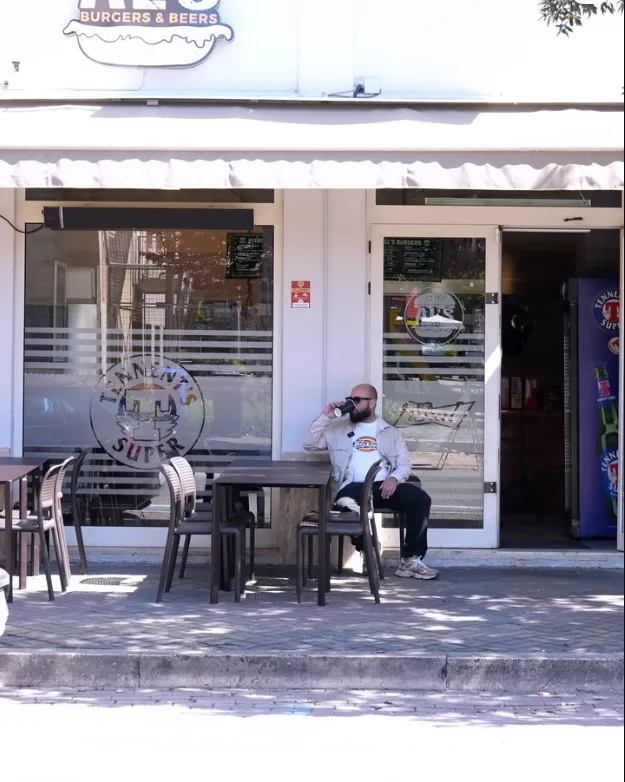 Il locale da fuori: i tavoli sotto la tenda e l'insegna sopra l'ingresso