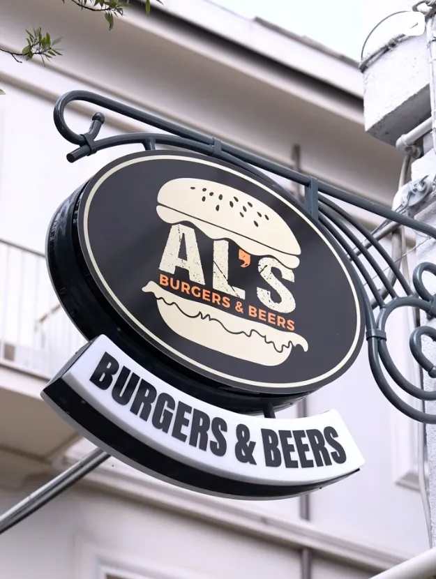 L'insegna a panino di Al's Burgers & Beers appesa fuori dal locale