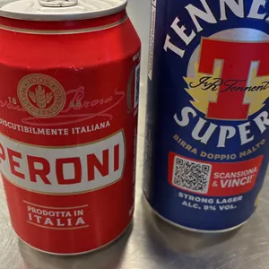 Due lattine di birra sul banco: Peroni e Tennent’s Super